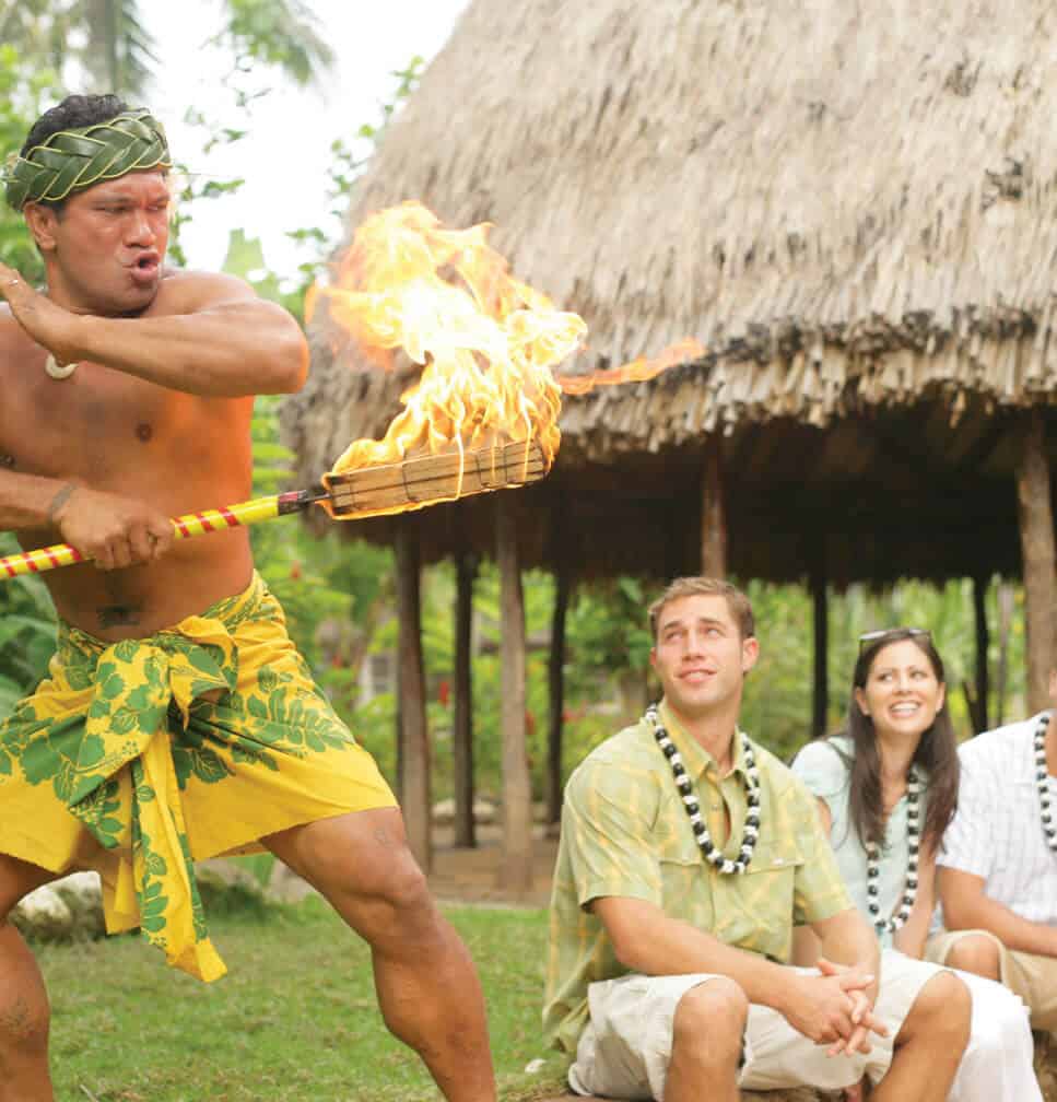 Guests watching a cultural demonstration in a village setting